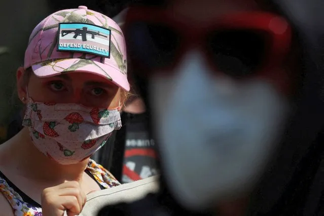 A counter-protestor wearing a cap with the transgender flag, a image of an assault rifle and the words “Defend Equality” demonstrates against an appearance by “Billboard Chris”, who opposes medical treatments for transgender youth, outside Children's Hospital in Boston, Massachusetts, U.S., September 18, 2022. (Photo by Brian Snyder/Reuters)