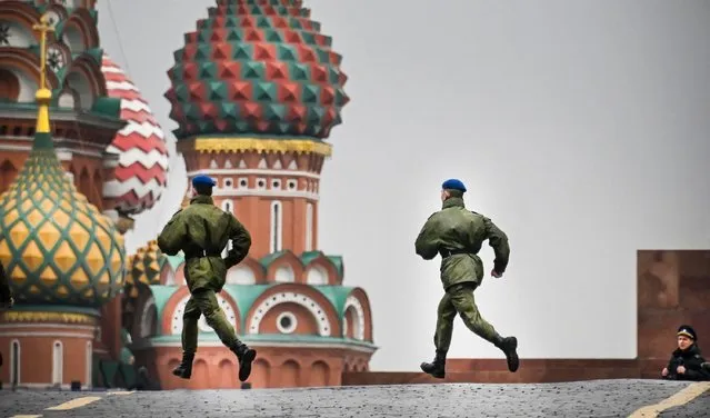Russian soldiers run along Red Square in central Moscow on September 29, 2022, as the square is sealed prior to a ceremony of the incorporation of the new territories into Russia. Russia will formally annex four territories of Ukraine its troops occupy at a grand ceremony in Moscow on Friday, the Kremlin has announced, after Russia suggested it could to use nuclear weapons to defend the territories. (Photo by Alexander Nemenov/AFP Photo)