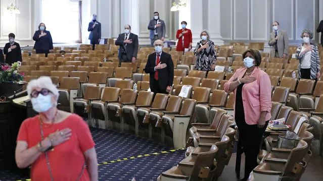 Members of the N.H. Senate stand for the Pledge of Allegience as they gather for a session on Tuesday, June 16, 2020 at the State House in Concord, New Hampshire. The 24 N.H. Senators met in the N.H. House Chamber while adhering to social distancing rules due to the COVID-19 virus outbreak. (Photo by Charles Krupa/AP Photo)