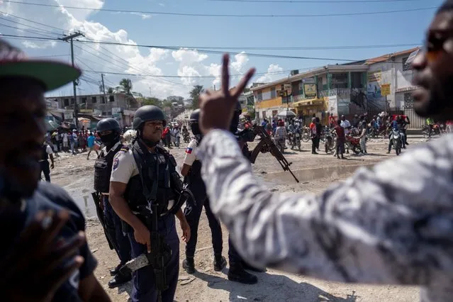 Protester gestures at Haitian National police officers during a protest demanding the resignation of Haiti's Prime Minister Ariel Henry after weeks of shortages in Port-au-Prince, Haiti on October 17, 2022. (Photo by Ricardo Arduengo/Reuters)