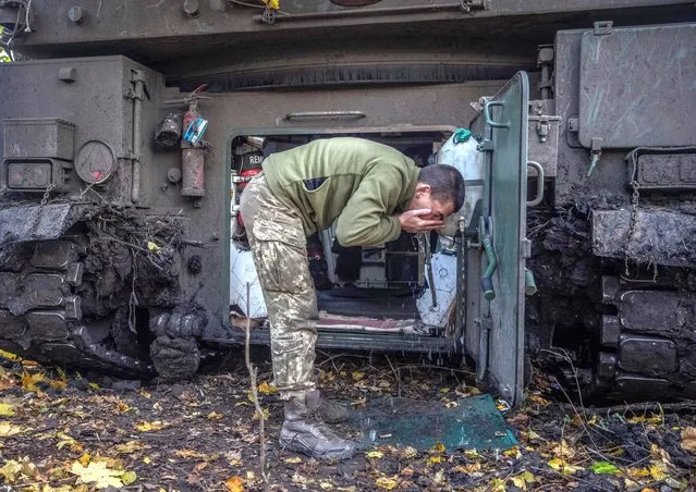 Ukrainian serviceman washes his face near a Polish self-propelled howitzer Krab after a fire toward Russian positions, amid Russia's attack on Ukraine, on a frontline in Donetsk region, Ukraine on November 8, 2022. (Photo by Oleksandr Ratushniak/Reuters)