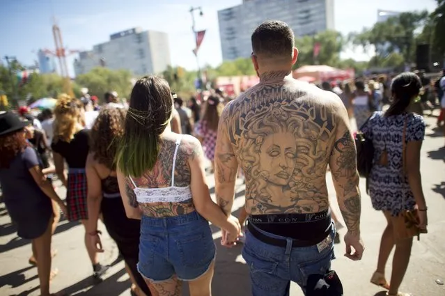 A couple walks hand-in-hand while attending the fourth annual Made in America Music Festival in Philadelphia, Pennsylvania, September 6, 2015. (Photo by Mark Makela/Reuters)