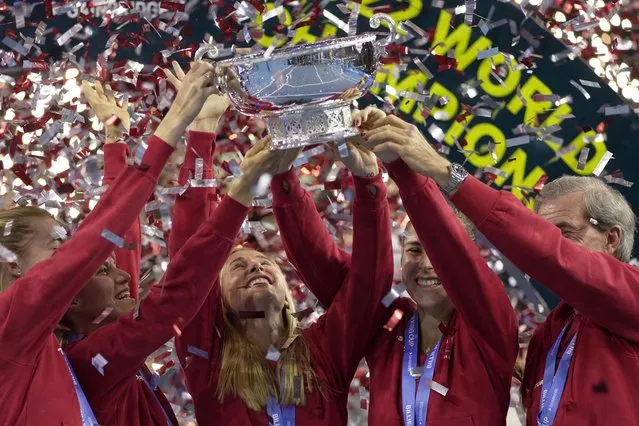 Switzerland's players Simona Waltert, Viktorija Golubic, Jil Teichmann, Belinda Bencic and Switzerland team captain Heinz Guenthardt, from left, celebrate with the trophy after defeating Australia to win the Billie Jean King Cup tennis finals, at the Emirates Arena in Glasgow, Scotland, Sunday, November 13, 2022. (Photo by Kin Cheung/AP Photo)