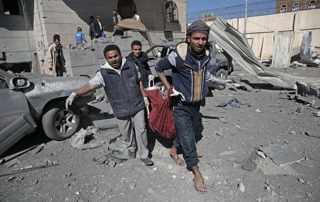 People carry the body of a man they uncovered from under the rubble of a Houthi-held detention center destroyed by Saudi-led airstrikes in Sanaa, Yemen, Wednesday, December 13, 2017. (Photo by Hani Mohammed/AP Photo)
