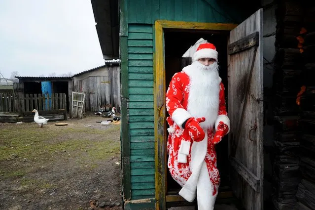A man dressed as Father Frost leaves a house as he celebrates the traditional Kalyady holiday in the village of Sredniye Pechi, some 290 km south of Minsk, on January 7, 2018. Kolyady is an ancient pagan holiday initially celebrated on winter solstice but since appropriated to celebrate Christmas, Julian calendar's New Year, and other winter holidays. (Photo by Sergei Gapon/AFP Photo)
