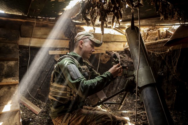 A handout photo made available by the press service of the 24th Mechanized Brigade of Ukrainian Armed Forces, shows a serviceman from the 2nd Rifle Battalion of the 24th Mechanised Brigade named after King Danylo, fires a 120 mm mortar at the outskirts of Chasiv Yar in the Donetsk region , Ukraine, 27 May 2025, amid the ongoing Russian invasion. (Photo by Ukrainian 24th Mechanised Brigade/EPA/EFE)