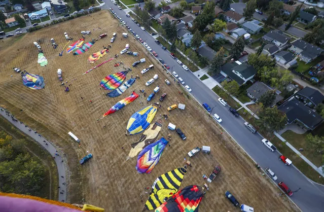 Balloons are seen from the air as they prepare for flight during the Heritage Inn International Balloon Festival near High River, Alta., Thursday, September 22, 2022. (Photo by Jeff McIntosh/The Canadian Press via AP Photo)
