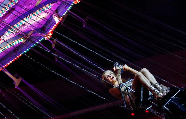 Model Paris Hilton smiles as she rides on a carousel during a party after the Philipp Plein fashion show during Milan Fashion Week Spring/Summer 2017 in Milan, Italy, September 21, 2016. (Photo by Alessandro Garofalo/Reuters)