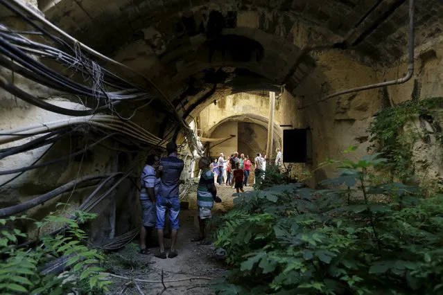 Visitors walk through a tunnel forming part of the old Malta Railway which was closed down in 1931 in Floriana, outside Valletta, Malta, October 18, 2015. Locals and tourists flocked to see part of the network of tunnels which were opened to the public on Sunday for only the fifth time in a generation, according to local media. (Photo by Darrin Zammit Lupi/Reuters)