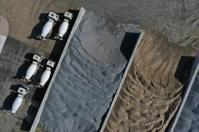 In this aerial view from a drone, cement trucks stand parked next to piled sand and gravel at the construction site of the new Tesla Gigafactory stands near Berlin on September 06, 2020 near Gruenheide, Germany. Tesla is planning to begin electric car production at the site by the summer of 2021 with 12,000 employees and an output of at least 100,000 cars annually. (Photo by Sean Gallup/Getty Images)