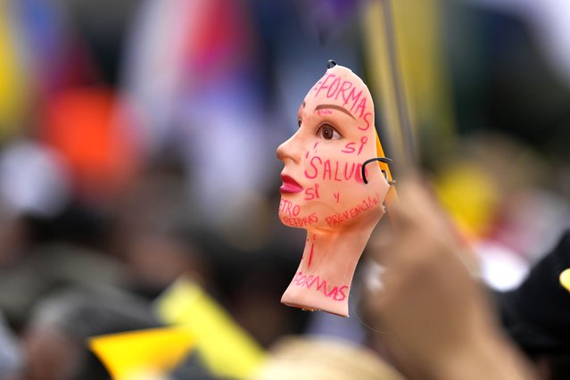 A doll's face is covered with supportive messages for government-proposed reforms during the International Workers' Day march in Bogota, Colombia, May 1, 2024. (Photo by Fernando Vergara/AP Photo)