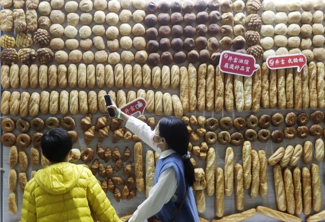 Two children looked at a whole wall of bread on display during the Bakery Show at Taipei Nangang Exhibition Center in Taipei, Taiwan, Sunday, February 19, 2023. (Photo by Chiang Ying-ying/AP Photo)
