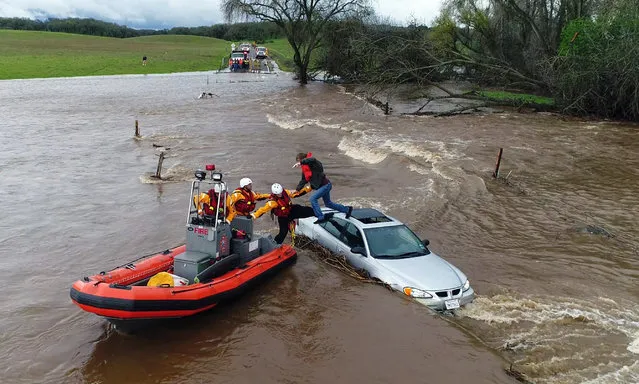 The Fire Department rescues a motorist who became stranded as a flash flood washed over a road near Folsom, USA on March 22, 2018. Powerful storms spread more rain across California on Thursday, swelling rivers. (Photo by Kelly B. Huston/AP Photo/California Governor's Office of Emergency Services)