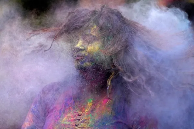 A woman shakes her head to dust off coloured powder from her hair during Holi celebrations in Mumbai, India on March 7, 2023. (Photo by Francis Mascarenhas/Reuters)