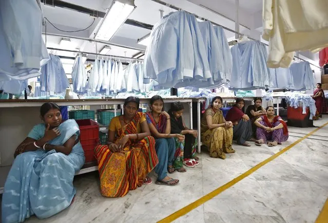 Employees sit during their lunch time inside a textile mill of Orient Craft Ltd. at Gurgaon in Haryana, northern India in this April 16, 2014 file photo. (Photo by Anindito Mukherjee/Reuters)