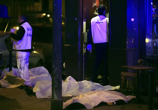 Victims lay on the pavement in a Paris restaurant, Friday, November 13, 2015. (Photo by Thibault Camus/AP Photo)