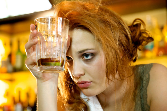 Young woman with a hangover holding her almost empty cocktail glass. (Photo by princigalli/Getty Images)