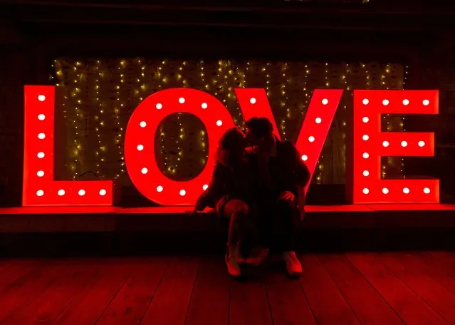 (L-R) Raina Kuan and Levi Swanky kisses in front of a led light marquee letters reading “LOVE” during Love Lights at Capilano Suspension Bridge Park ahead of Valentine's Day on February 12, 2022 in North Vancouver, British Columbia, Canada. (Photo by Andrew Chin/Getty Images)