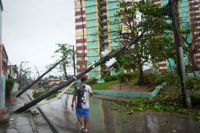 A man takes pictures of fallen electrical posts on the street in the aftermath of Hurricane Melissa in Santiago, Cuba, on October 29, 2025. (Photo by Alexandre Meneghini/Reuters)