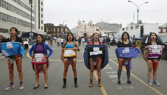 Women, with their bodies painted with blood, hold signs reading "2,074 women were sterilized without their consent by the government of Fujimori" during a protest near the Attorney General's Office in Lima, November 18, 2015. Amnesty International pressed Peruvian President Ollanta Humala on July 2015 to track down scores of poor Andean women who might have been forcibly sterilized by government doctors in the late 1990s. (Photo by Mariana Bazo/Reuters)