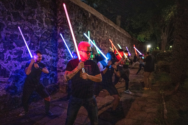 Members of the Jedi Knight Academy (JKAMX) hold lightsabers during training at a park in Mexico City on July 6, 2024. Members of JKAMX, a community of Star Wars enthusiasts who train in swordsmanship skills using lightsabers, undergo exams and tournaments to advance in ranks to become a Jedi Master swordsmen. Their sport has now spread to various Mexican states and has been recognized by the Mexican Sport Confederation (CODEME) and the National Commission of Sport (CONADE). (Photo by Carl de Souza/AFP Photo)