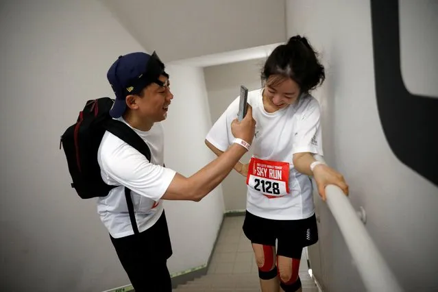 A participant takes photographs of his friend while climbing up the stairs during Sky Run, a vertical marathon event, held in the 123-story Lotte World Tower, in Seoul, South Korea on April 22, 2023. (Photo by Kim Soo-hyeon/Reuters)