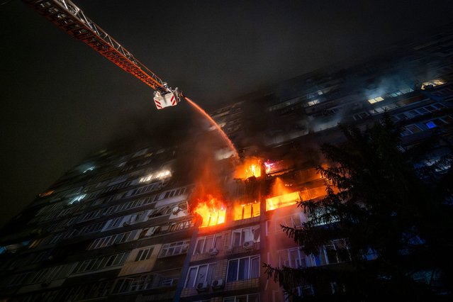 Emergency services personnel work to extinguish a fire following a Russian attack in Kyiv, Ukraine, Friday, October 10, 2025. (Photo by AFP Photo/Stringer)