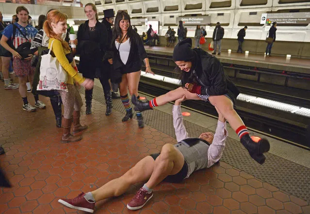 A participant in the No Pants Subway Ride DC lifts a fellow participant while waiting for a train at the Gallery Place – Chinatown station on January 11, 2015 in Washington, DC. (Photo by Mandel Ngan/AFP Photo)