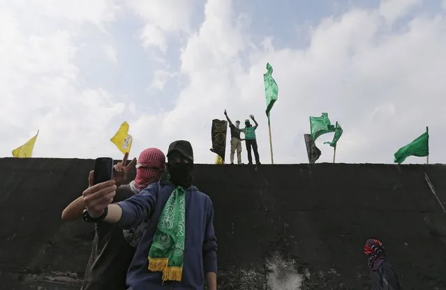 Palestinian protesters take a selfie in front of a section of the Israeli barrier that separates the West Bank town of Abu Dis from Jerusalem, during an anti-Israel protest, November 16, 2015. (Photo by Ammar Awad/Reuters)