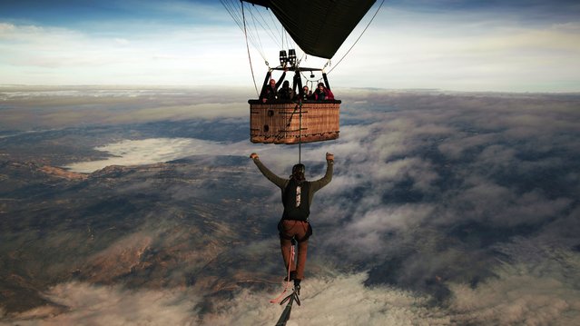 A slackliner, Alexander Schulz, balancing on a line suspended between two hot air balloons above Catalonia, Spain in the last decade of November 2025, at 4700 meters above ground. (Photo by One Inch Dreams/Caters News Agency)