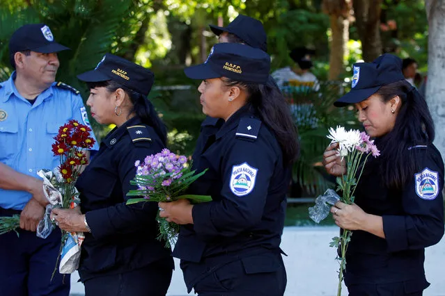 Police officers hold flowers as they take part in the commemoration of the 40th anniversary of the death of Carlos Fonseca, founder of Sandinista party, in Managua, Nicaragua November 8, 2016. (Photo by Oswaldo Rivas/Reuters)