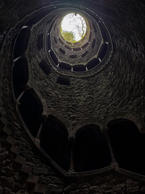 One of Portugal's fairytale towns, Sintra, located amidst lush forests and rugged hills, attracting thousands of local and foreign tourists every year with its rich palaces, magnificent villas, and historical sites, on March 6, 2025. A UNESCO World Heritage site, the town was a summer residence for Portuguese nobility due to its cool climate. Quinta da Regaleira, built by Antonio Augusto de Carvalho Monteiro in the late 17th century, features a variety of structures including a palace, chapel, bridge, well, park, lake, tunnels, and caves. The Initiation Well, shaped like an inverted tower and adorned with mystical and pagan symbols, features a spiral staircase with 9 levels. It is one of the main attractions for tourists. (Photo by Gul Meltem Temiz Sahin/Anadolu via Getty Images)