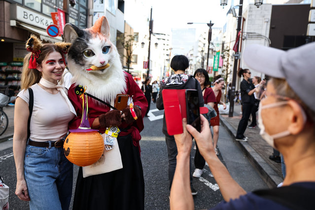 Participants pose for a photograph during Kagurazaka Bakeneko Festival on October 13, 2024 in Tokyo, Japan. The annual festival in Kagurazaka invites participants to embrace their feline side by dressing up as cats and showcasing their playful spirit. This unique Halloween-themed event offers a festive atmosphere with activities such as cat makeup, kimono rentals, making it a delightful experience for all ages. (Photo by Takashi Aoyama/Getty Images)