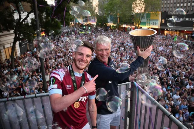 West Ham United's English midfielder Declan Rice and West Ham United's Scottish manager David Moyes hold the UEFA Europa Conference League trophy on stage at the Town Hall in Stratford, east London on June 8, 2023, following an open-top bus during a parade to celebrate the team winning the football final against Fiorentina. (Photo by Daniel Leal/AFP Photo)
