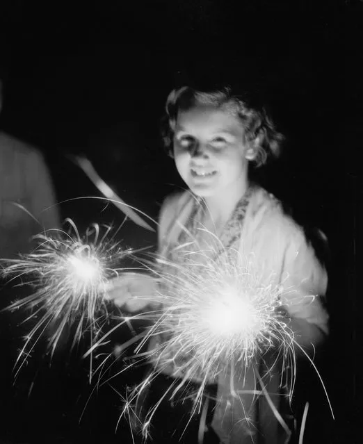 Girl with sparkler on the 4th of July, 1930. (Photo by Bettmann Archive/Getty Images)
