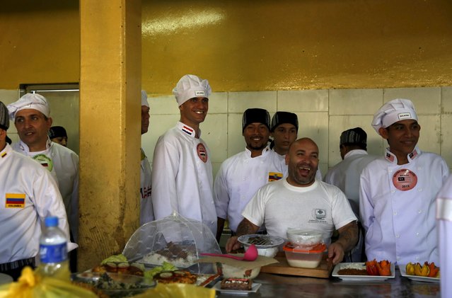 Inmates stand next to food during a Christmas event at Sarita Colonia male prison in Callao, Peru, December 18, 2015. For the event, inmates prepared Christmas meals for a culinary competition and took part in dances and songs. (Photo by Mariana Bazo/Reuters)