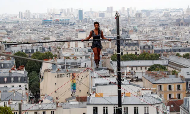 Tightrope walker Tatian-Mosio Bongonga advances on a tightrope as she scales the Monmartre hill towards the Sacre Coeur Basilica (not pictured) in Paris, France, July 20, 2018. (Photo by Philippe Wojazer/Reuters)