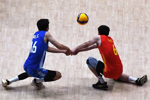 Yu Yuantai (R) and Qu Zhongshuai of China hit a return against Japan during their Nations League volleyball match at the Mall of Asia arena in Pasay City, suburban Manila on July 4, 2023. (Photo by Ted Aljibe/AFP Photo)