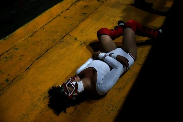 Zuzu Divine lies down on the floor during a wrestling fight at Arena Neza on the outskirts of Mexico City, Mexico October 28, 2016. (Photo by Carlos Jasso/Reuters)