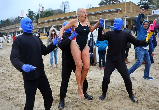 A swimmer is lifted by the actors of the Blue Man Group performing on the opening day of the pool season at the Wannsee lido, as the event was cancelled for two years in a row amid the coronavirus disease (COVID-19) pandemic, in Berlin, Germany on April 15, 2022. (Photo by Fabrizio Bensch/Reuters)