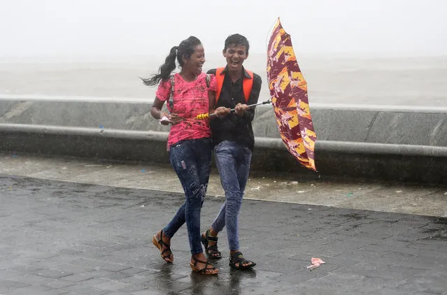 A couple share a moment on a rainy day in Mumbai, July 16, 2018. (Photo by Francis Mascarenhas/Reuters)