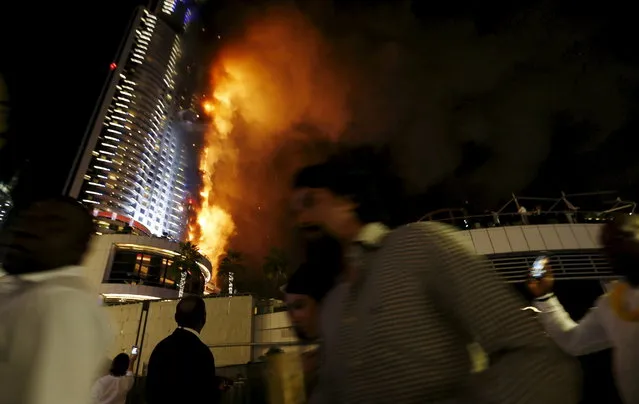 People run away as a fire engulfs The Address Hotel in downtown Dubai in the United Arab Emirates December 31, 2015. (Photo by Ahmed Jadallah/Reuters)