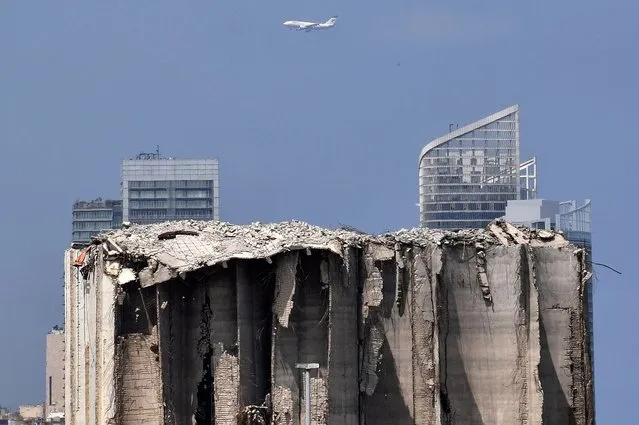 A plane flies over the damaged wheat silos ahead of the third anniversary of a huge explosion that hit the Port of Beirut, Lebanon, 01 August 2023. At least 200 people were killed and more than 6,000 injured in the blast that devastated the port area of Beirut on 04 August 2020, believed to have been caused by an estimated 2,750 tons of ammonium nitrate stored in a warehouse. (Photo by Wael Hamzeh/EPA)