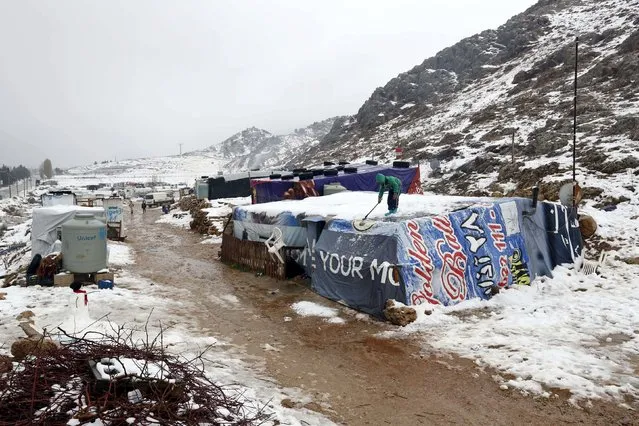 A Syrian child Yahya from Raqqa clean snow cover his tent in the Bekaa Valley in Lebanon after the first heavy snow storm hits Lebanon,January 3,2016. (Photo by Jamal Saidi/Reuters) 