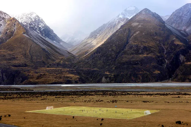 This handout photograph taken by Brett Phibbs on 20 June 2023, and released by Tourism New Zealand shows Tourism New Zealand celebrating one month to go until the FIFA Womenís World Cup 2023ô by installing a full size football pitch at Aoraki Mount Cook. The pitch hosted an exhibition match between local girls as well as a training session with Football Ferns Katie Bowen and Emma Rolston, dubbed the Beautiful Game, played in one of the most beautiful places on earth – New Zealand. (Photo by Brett Phibbs/Tourism New Zealand via AFP Photo)