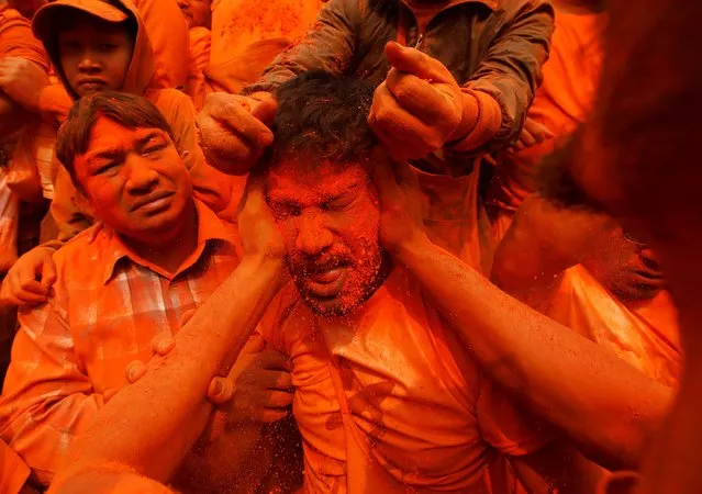 A devotee is smeared with vermilion powder while celebrating “Sindoor Jatra” vermillion powder festival to welcome the arrival of spring and Nepali new year, amidst the spread of the coronavirus disease (COVID-19), at Thimi, in Bhaktapur, Nepal, April 15, 2021. (Photo by Navesh Chitrakar/Reuters)