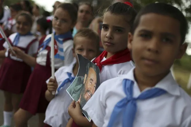 Schoolchildren line a road while awaiting the caravan carrying Cuba's late President Fidel Castro's ashes in Majagua, Cuba, December 1, 2016. (Photo by Carlos Garcia Rawlins/Reuters)