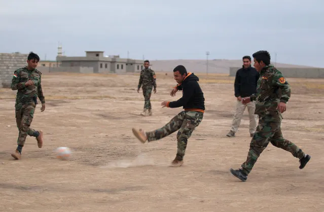 Peshmerga forces play football in the town of Bashiqa, after it was recaptured from the Islamic State, east of Mosul, November 30, 2016. (Photo by Khalid al Mousily/Reuters)