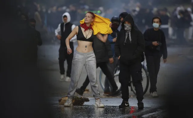 A woman demonstrates at the Bois de la Cambre park during a party called “La Boum 2” in Brussels, Saturday, May 1, 2021. A few thousand people gathered for an illegal party in a Brussels park Saturday to protest COVID-19 restrictions, only to be met with a big police force who used a water cannon and tear gas to disperse the crowd. It was the second such open-air gathering in a month. (Photo by Olivier Matthys/AP Photo)