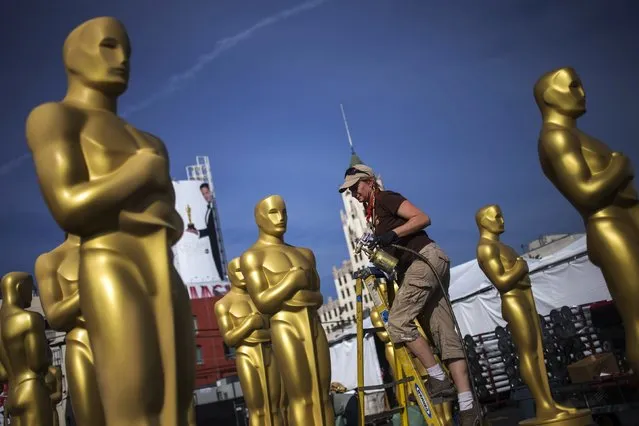 Dena D'Angelo, a scenic artist, prepares to spray Oscar statues in a parking lot near the Dolby Theatre in Hollywood, ahead of the Academy Awards in Los Angeles, California February 18, 2015. The 87th Academy Awards ceremony, which honors the best films of 2014, will take place Sunday at the Dolby Theatre in Hollywood. (Photo by Adrees Latif/Reuters)